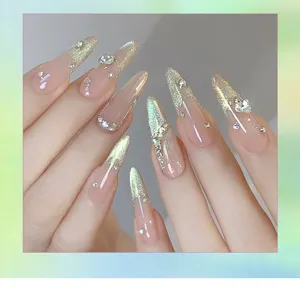 Detail of stiletto nails with green cat-eye effect, sparkling rhinestones, and glitter