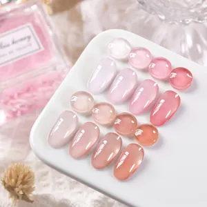 Gros plan d'échantillons de vernis gel rose nude transparent sur un plateau blanc