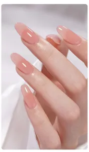 Gros plan d'un vernis gel rose nude translucide et brillant sur des ongles en amande