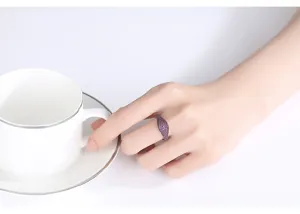 Vista detallada de una mano con un anillo de sello estilo hip-hop con espinela morada
