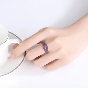 Elegante anillo hip-hop unisex con piedras de espinela púrpura sobre fondo blanco