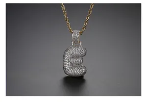 Detalle del colgante de letra e minúscula estilo hip hop con circonitas y cadena cordón