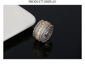 Close-up detail of ornate gold and silver toned iced out ring with scalloped edges