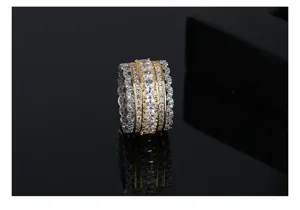 Close-up of a two-tone wide band ring with multi-row sparkling stones and scalloped edges