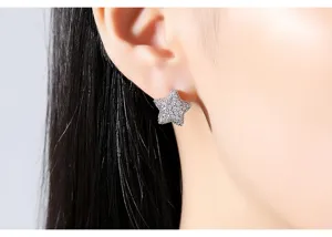 Detail view of a shimmering star-shaped stud earring pavé-set with clear zircons.