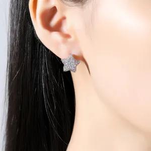 Dainty star-shaped stud earrings micro-paved with sparkling cubic zirconia on model