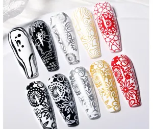 Vista detallada de varios patrones de nail art impresos en puntas de uñas postizas blancas