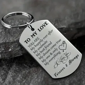 Detailed view of engraved inspirational dog tag keychain on a dark stone background