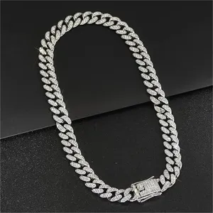 Detailed macro view of an iced out silver Cuban link chain with a rhinestone box clasp