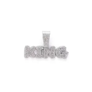 Macro view of silver-tone iced-out KING pendant encrusted with sparkling clear crystals