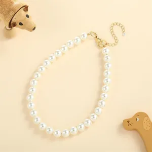 Detailed view showing the elegant white faux pearl dog necklace with adjustable gold clasp