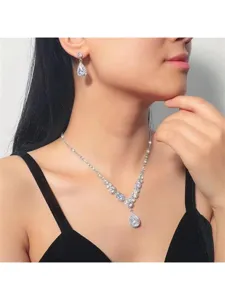 Vista dettagliata di un set di gioielli da sposa con collana a V e orecchini a goccia.