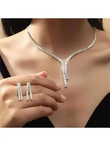Dettaglio del set da sposa con collana a V e orecchini in zircone su collo e mano
