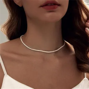 Close-up of an elegant sparkling silver tennis necklace worn by a female model.