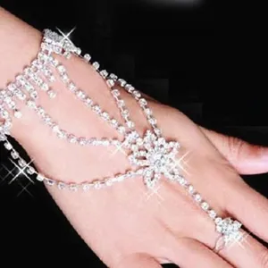 Vue détaillée d'un bracelet en strass étincelant relié à une bague sur la main d'un modèle