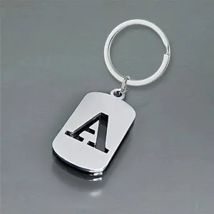 Macro detail of a silver stainless steel keychain featuring a hollowed-out letter A tag