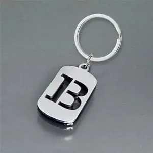 Detailed view of a silver stainless steel keychain featuring a hollow-out letter B design