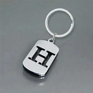 Detailed view of a minimalist stainless steel keychain featuring a hollowed-out letter H.
