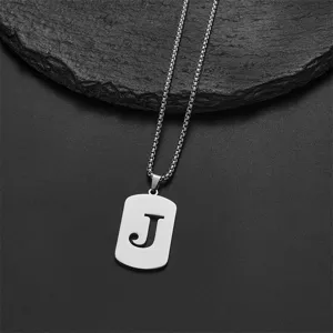 Detailed macro shot of stainless steel pendant with letter J cutout on box chain