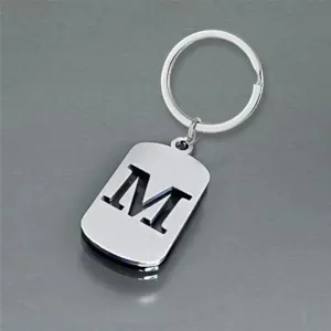 Detailed view of stainless steel keychain with hollowed-out letter M design