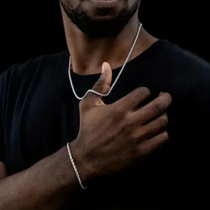 Conjunto de collar y pulsera de cadena de cuerda plateada en un modelo con camisa negra