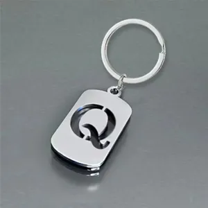 Detailed macro view of a polished stainless steel keychain featuring a cutout letter Q design