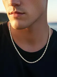 Detalle de una cadena de cuerda dorada lucida por un modelo masculino al atardecer