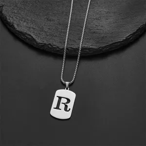 Close-up of silver stainless steel pendant necklace featuring cut-out letter R