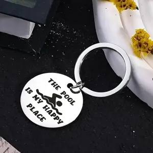 Detailed close-up of a round stainless steel keychain featuring a swimming pool engraving