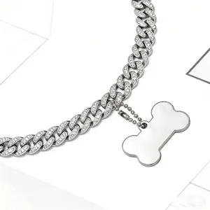 Close-up of iced out silver Cuban link pet collar with bone shaped pendant detail