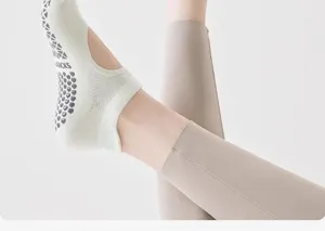 Close-up of mint green yoga socks with heart-shaped anti-slip grip and open back design