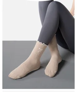 Close-up of beige yoga socks with anti-slip silicone dots and bow embroidery