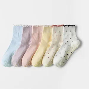 Detailed view of six pairs of pastel ruffle edge polka dot socks featuring non-slip soles