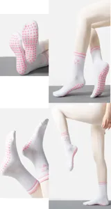 Dettaglio di calze da yoga bianche con antiscivolo rosa a forma di cuore sul fondo