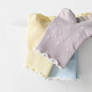 Detailed close-up of pastel ruffled polka dot socks with non-slip grips for yoga and Pilates.