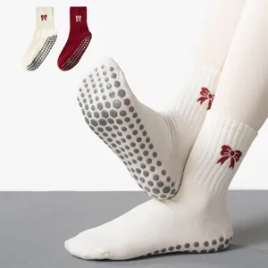 Close-up detail of professional anti-slip yoga socks with silicone grippers and bow embroidery.