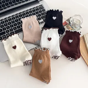 Detailed view of non-slip yoga socks with heart embroidery and ruffled edges in assorted colors