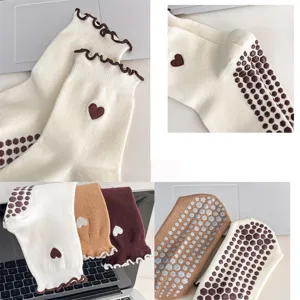 Close-up detail of anti-slip yoga socks with embroidered heart and stylish ruffle trim