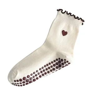 Professional non-slip yoga socks featuring heart embroidery and cream ruffle trim details.