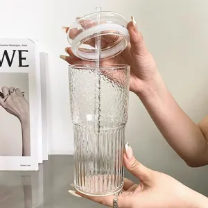 Detailansicht einer Hand, die ein strukturiertes Glas mit Deckel hält