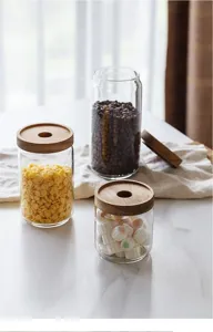 Close-up view of clear glass kitchen storage jars featuring natural acacia wood lids