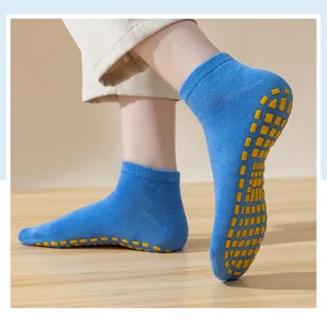 Detalle de calcetines antideslizantes azules con agarre de silicona amarillo en suelo