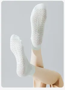 Dettaglio dei gommini antiscivolo in silicone su calze yoga verdi