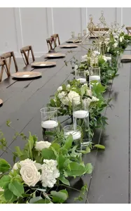 Elegante Hochzeitsdekoration mit Schwimmkerzen in Glaszylindern und weißen Rosen