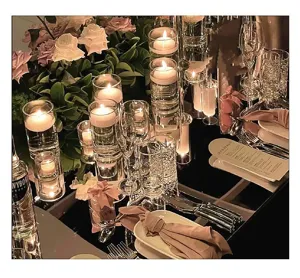 Detail van glazen kandelaars met drijvende kaarsen op een romantische tafel