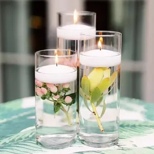 Elegante glazen cilinders voor drijfkaarsen met botanische accenten voor decor.