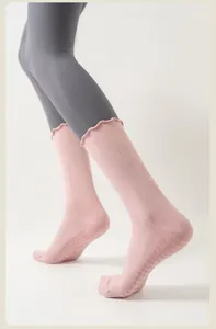 Nahaufnahme von rosa rutschfesten Yogasocken mit Rüschenkante und PVC-Griffpunkten