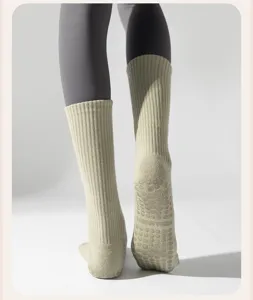 Macro view of anti-slip silicone grips on mid-calf cotton yoga socks for pilates