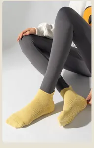 Dettaglio delle calze da yoga gialle con impugnature in silicone antiscivolo sulla suola