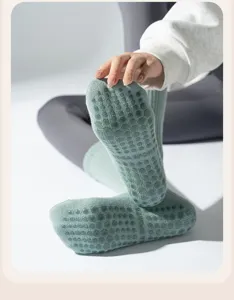 Detail view of non-slip silicone grip dots on mint green thick cotton yoga socks